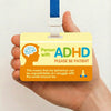A yellow awareness card for people with ADHD with a blue lanyard being held in a hand.