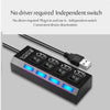 A black 7-port USB hub with individual power switches and blue LED indicators is shown on a gray background.