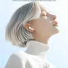 A close-up of a woman wearing Lenovo genuine Bluetooth headset earbuds while listening to music.