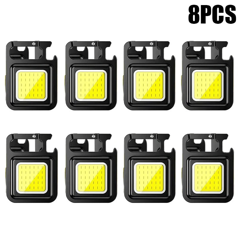 Eight compact COB keychain flashlights with magnetic bases and rechargeable batteries.