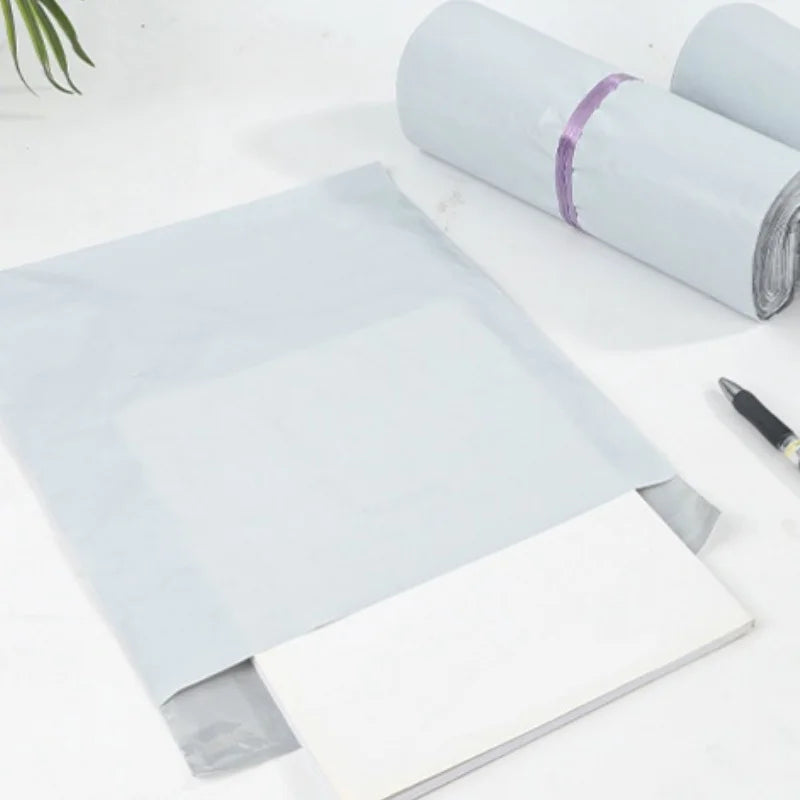 A stack of clear self-adhesive sealed packing bags with a purple ribbon detail on the top roll.