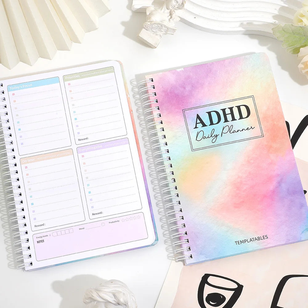 A pink and purple ADHD Daily Planner notebook with a task organizer and lined pages is shown on a white surface.