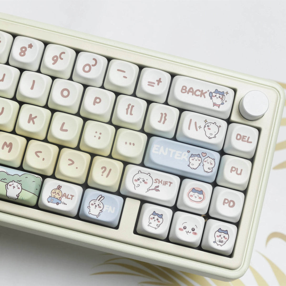 A close-up view of a light beige mechanical keyboard with white keycaps and a gold patterned surface.