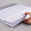 A hand holds a stack of white A4 transparent plastic document folders with a small white tab visible.