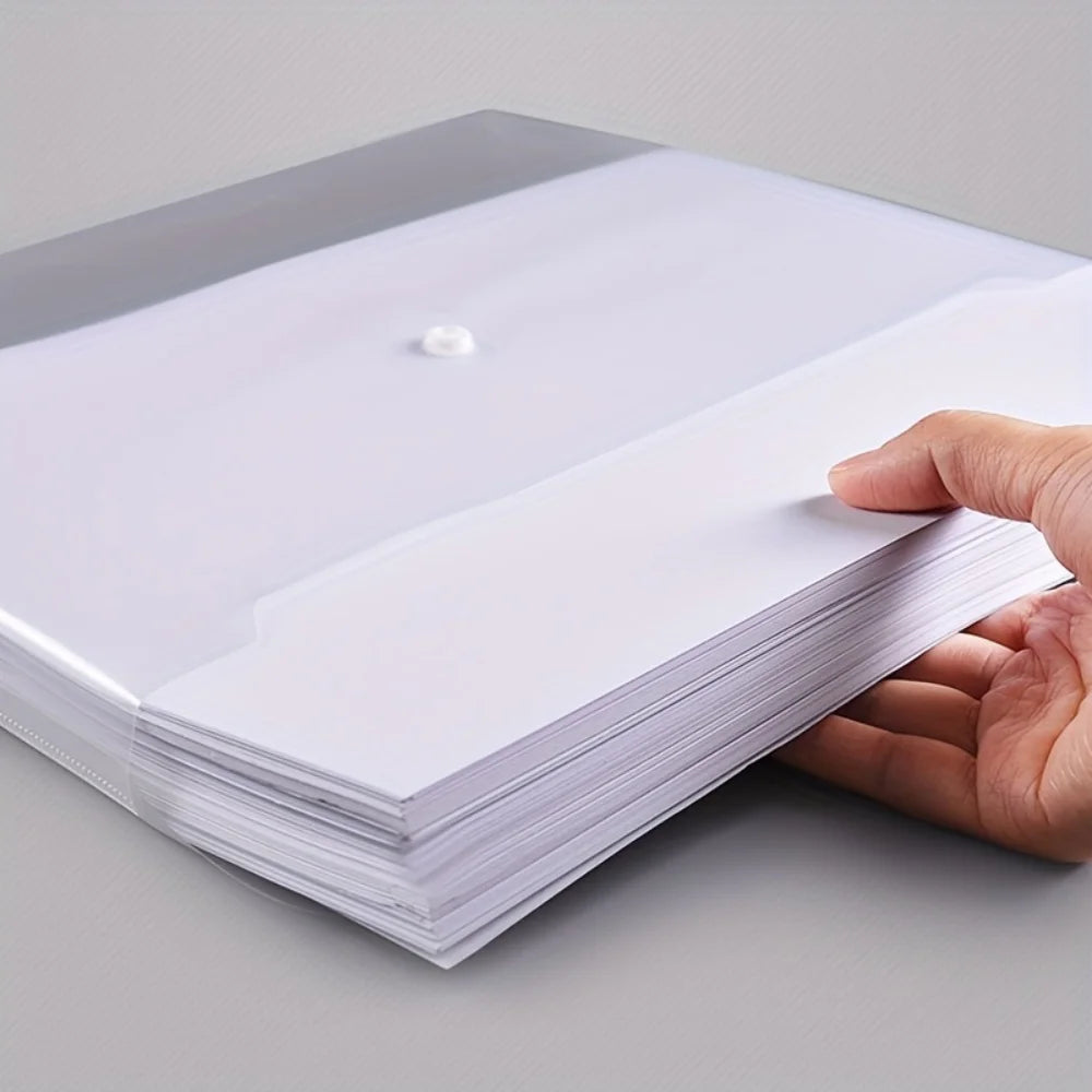 A hand holds a stack of white A4 transparent plastic document folders with a small white tab visible.