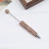 A silver pen accessory with a rhinestone-covered tip and a decorative top, displayed on a white background.