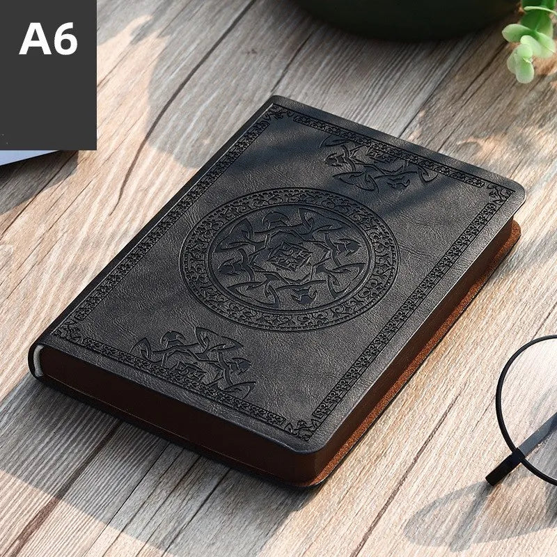 A dark brown retro PU leather pocket notebook lying on a wooden surface.