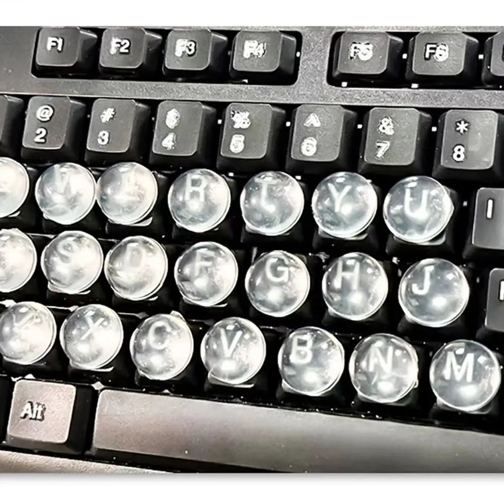 Close-up view of a black keyboard with transparent silicone stickers for long nails