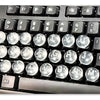Close-up view of a black keyboard with transparent silicone stickers for long nails