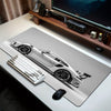 A large sports car pattern gaming mousepad displayed on a wooden desk with a keyboard and mouse visible.