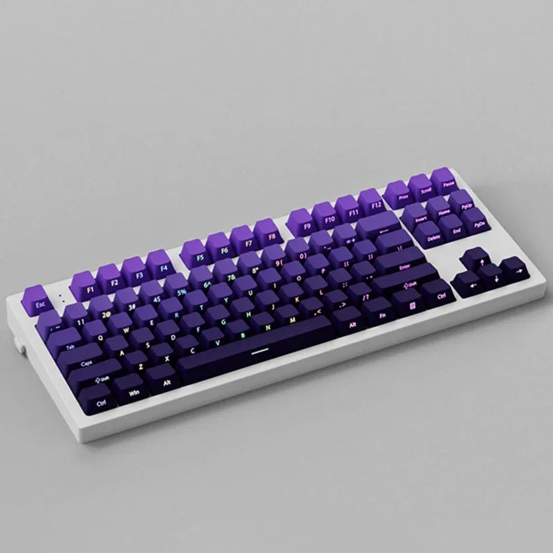 A close-up view of a purple mechanical keyboard featuring an RGB backlit gradient keycap set.