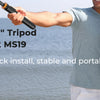 A person holds a magnetic selfie stick tripod for taking photos, with other people visible in the background.