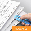 A hand is clamping a blue mini reusable hand clamp stapler onto a stack of paper documents.
