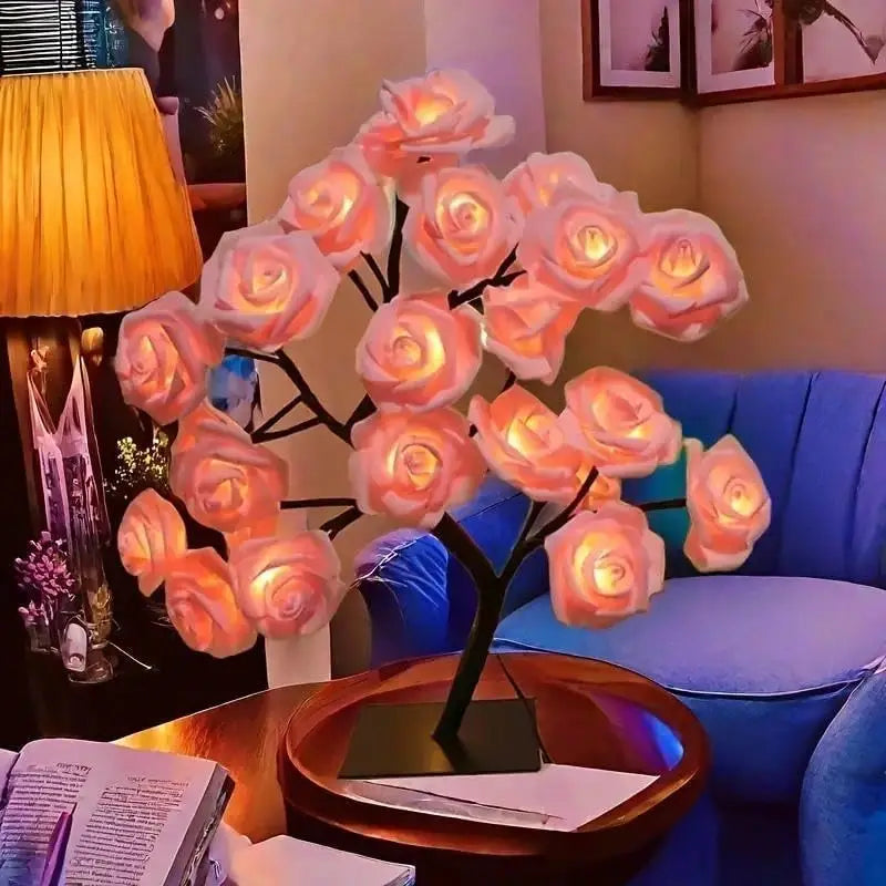 A pink rose tree LED night light displayed on a wooden table next to a blue armchair.