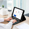 A person is using a Bluetooth keyboard case for an iPad on a wooden table with documents nearby.