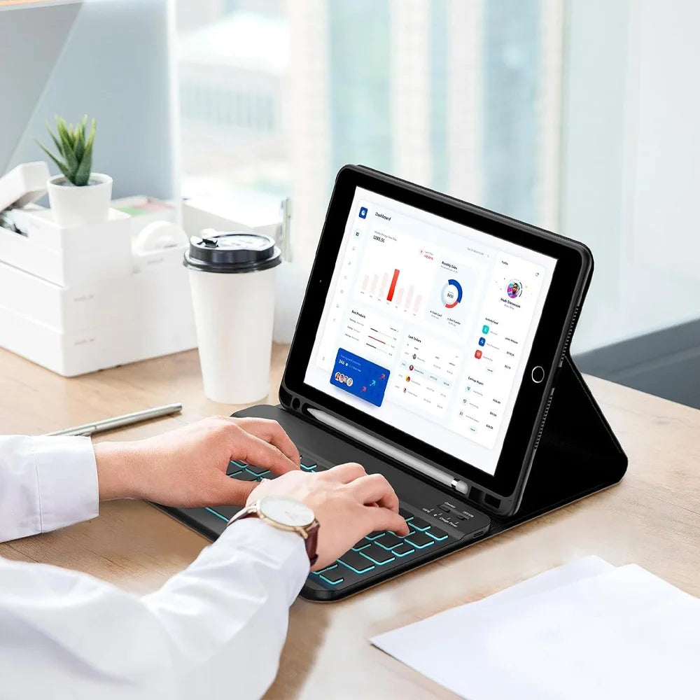 A person is using a Bluetooth keyboard case for an iPad on a wooden table with documents nearby.