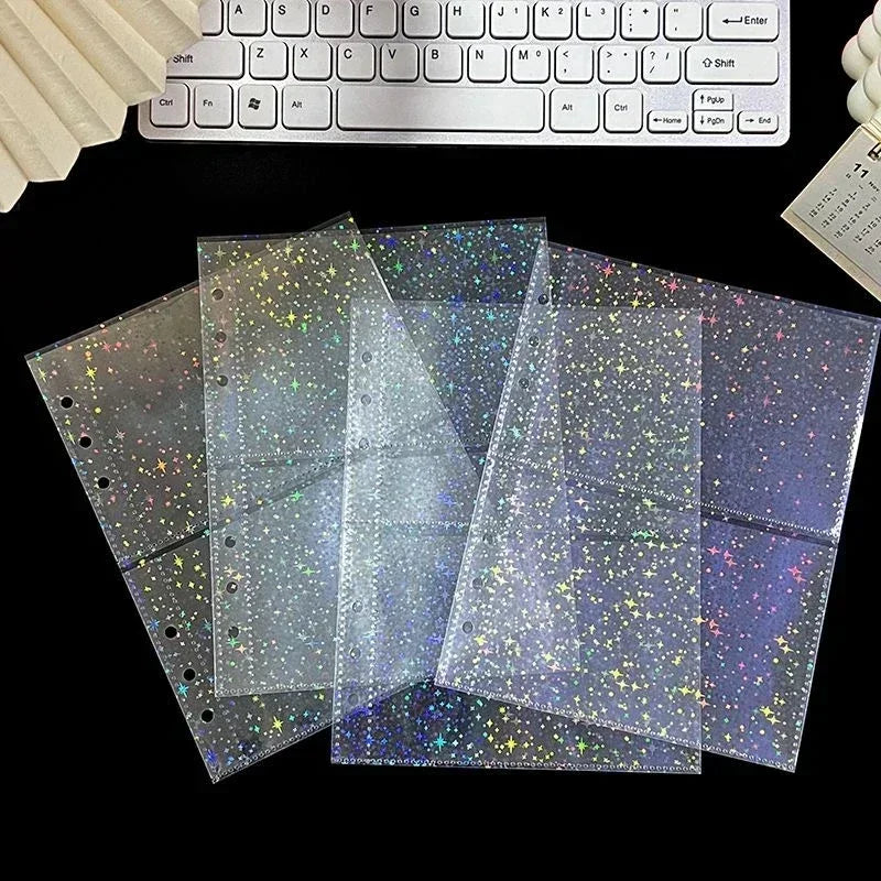 A stack of clear, iridescent photo sleeves with glitter and holographic effects are displayed next to a computer keyboard.