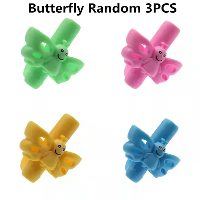 Three random silicone pencil grips in green, pink, and yellow for children's handwriting aid.