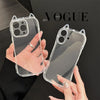 A hand holds a clear silicone case for an iPhone with 3D cat ears design against a dark background.