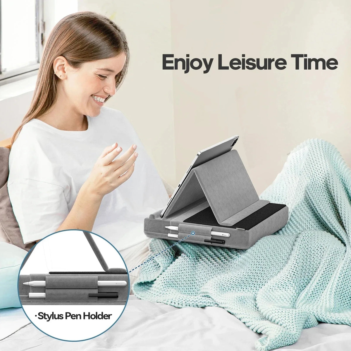 A woman is relaxing in bed with a foldable tablet pillow stand and stylus pen holder on the bed.