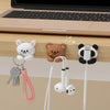 A set of cartoon desk cable organizers featuring bear and panda heads with white cords for managing wires.