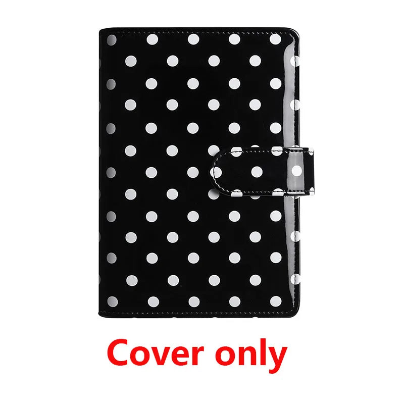 Black binder cover with white polka dots and a black elastic strap.
