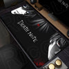 A black mouse pad featuring Death Note imagery, including a stylized face and text, placed on a wooden desk surface.