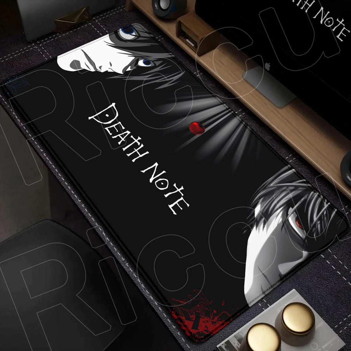 A black mouse pad featuring Death Note imagery, including a stylized face and text, placed on a wooden desk surface.