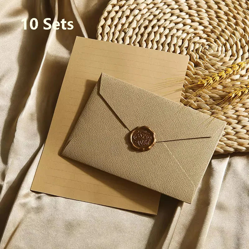 Zehn Sets beige Leinenumschläge und Briefe mit Wachssiegeln auf einer geflochtenen Matte.