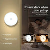 A white motion sensor LED night light illuminates a bedroom setting, showing both white and warm light options.