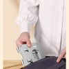 A hand holds a silver 360° rotating tablet stand against a dark gray fabric.