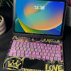 A purple keyboard case with an RGB backlit trackpad is shown next to an iPad displaying a time.