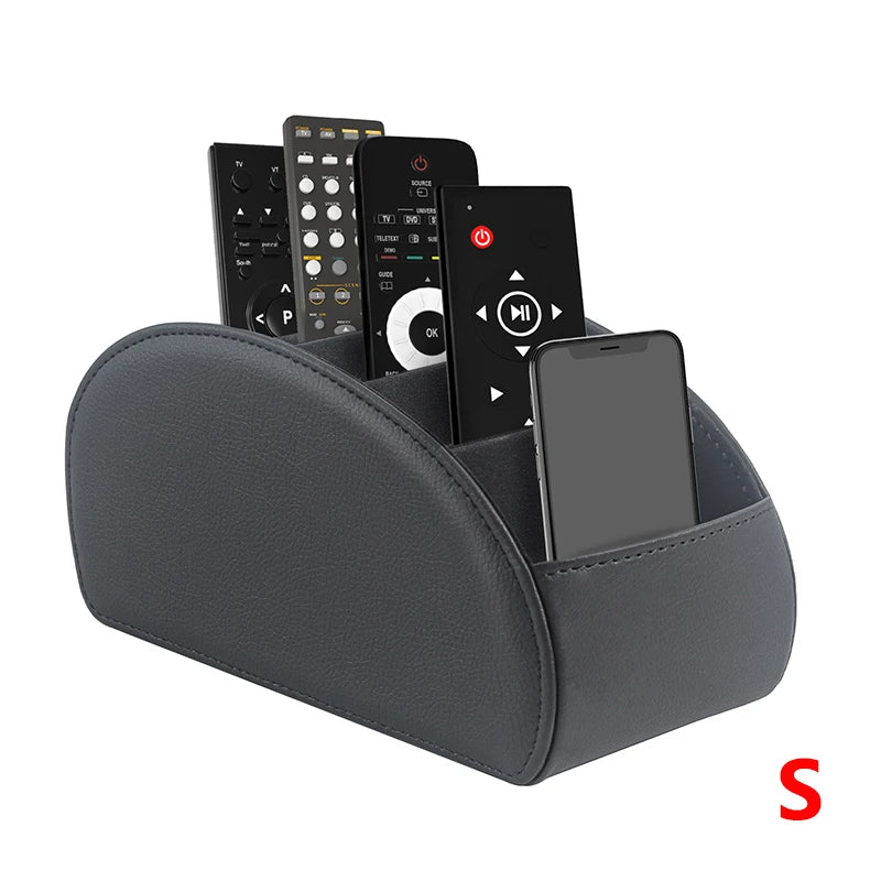 A dark gray PU leather caddy organizer holding a smartphone and three TV remotes.