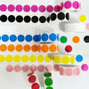 A collection of round dot labels in various colors including pink, purple, black, white, blue, green, and orange arranged in 
