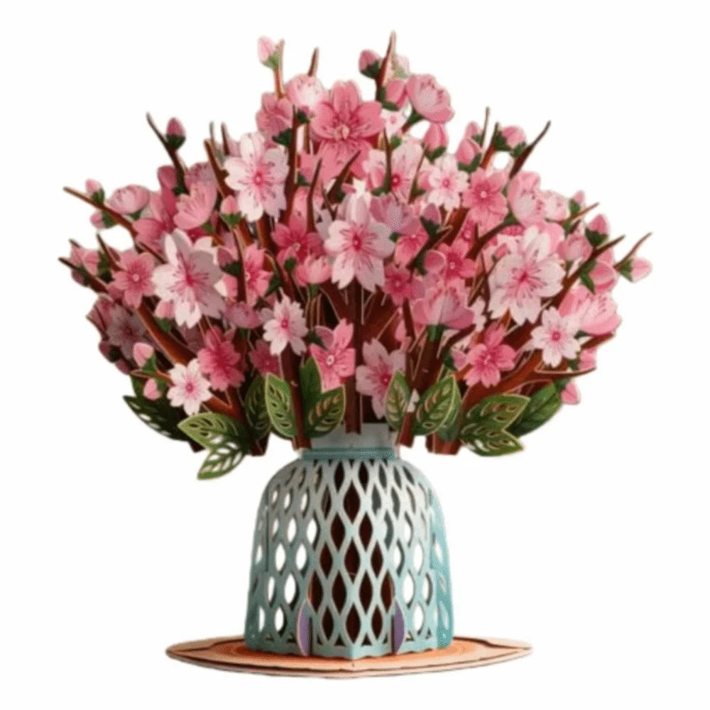 A bouquet of pink cherry blossoms arranged in a light blue ceramic vase on a wooden coaster.