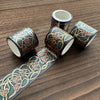 A set of metallic gold washi tape rolls featuring intricate floral designs for journaling and crafts.