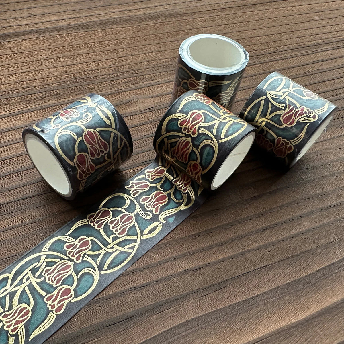 A set of metallic gold washi tape rolls featuring intricate floral designs for journaling and crafts.