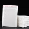 A stack of white self-sealing pearl film bubble shipping bags is shown on a dark surface.