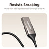 A close-up view of a silver portable Bluetooth car audio adapter with a microphone and black cable.