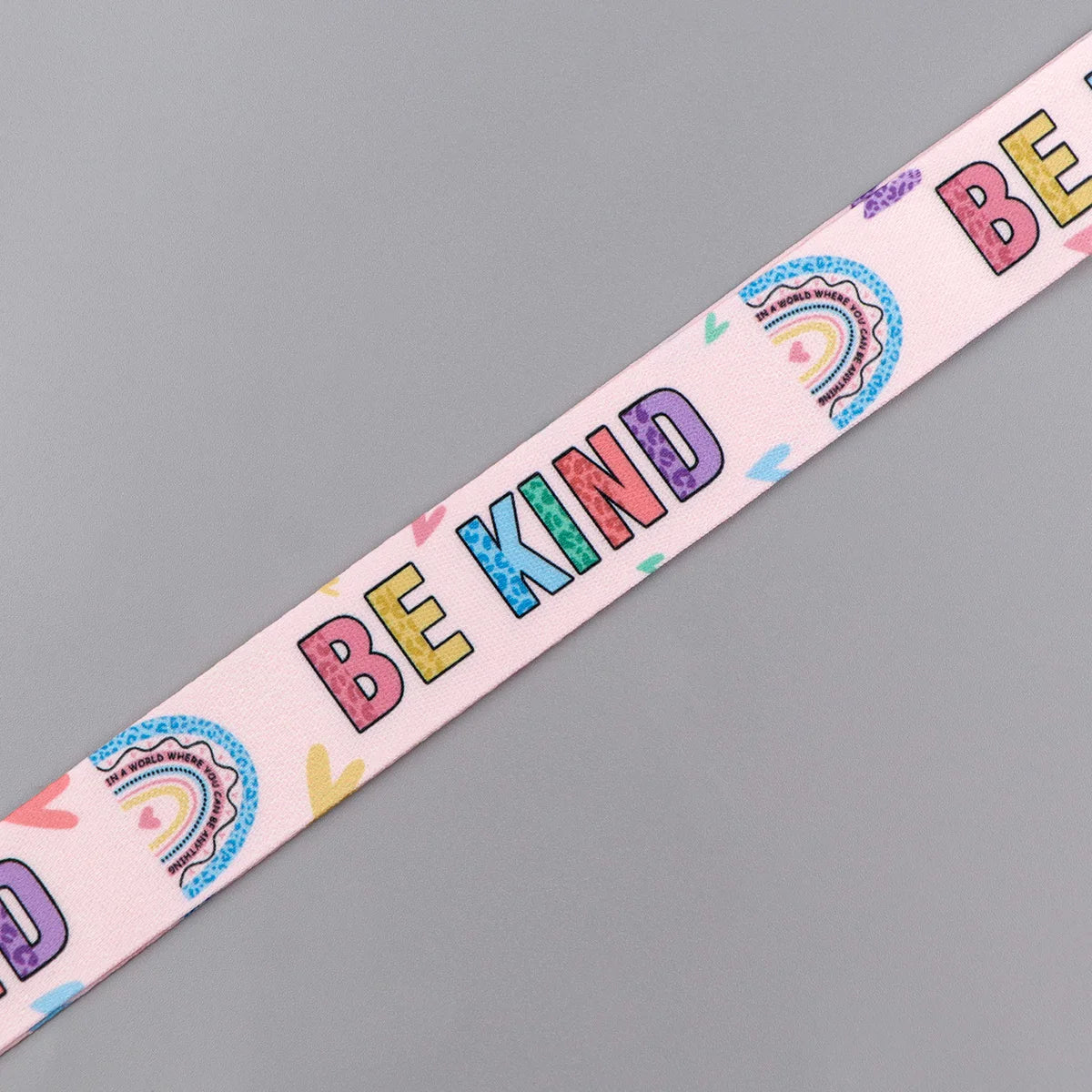 Pink lanyard with rainbow text spelling out BE KIND