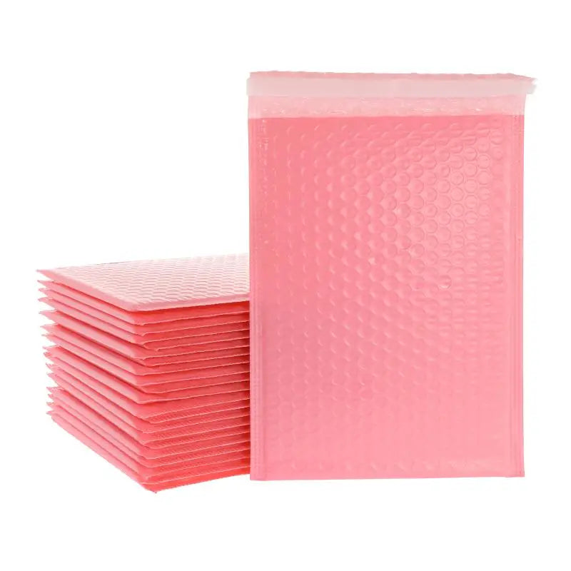 A stack of pink padded bubble mailers with self-seal closures.