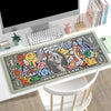 An extended gaming desk mat featuring a colorful, graffiti-style design with dollar signs and cartoon characters.