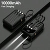A black 10000mAh multi-port power bank with a flashlight is shown lying on a dark surface.