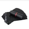 Stack of black self-adhesive sealing storage bags with a rolled bag on top