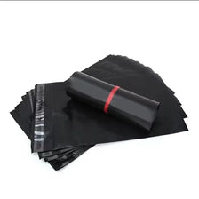 Stack of black self-adhesive sealing storage bags with a rolled bag on top