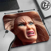 A close-up of a mouse pad featuring a realistic doll face design with long brown hair and an intense expression.