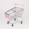 A pink mini shopping cart desktop organizer made of metal with rolling wheels and side pockets.
