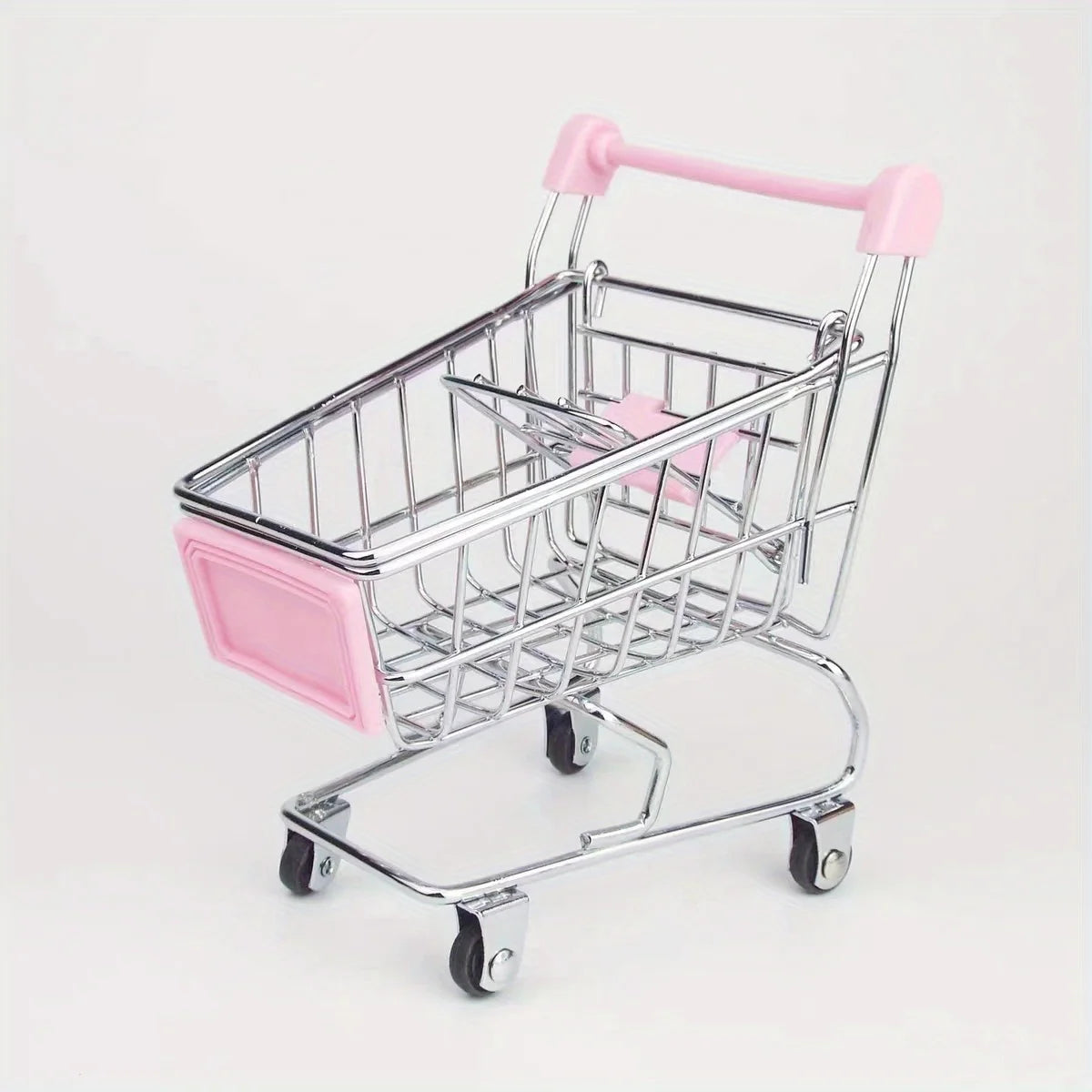 A pink mini shopping cart desktop organizer made of metal with rolling wheels and side pockets.