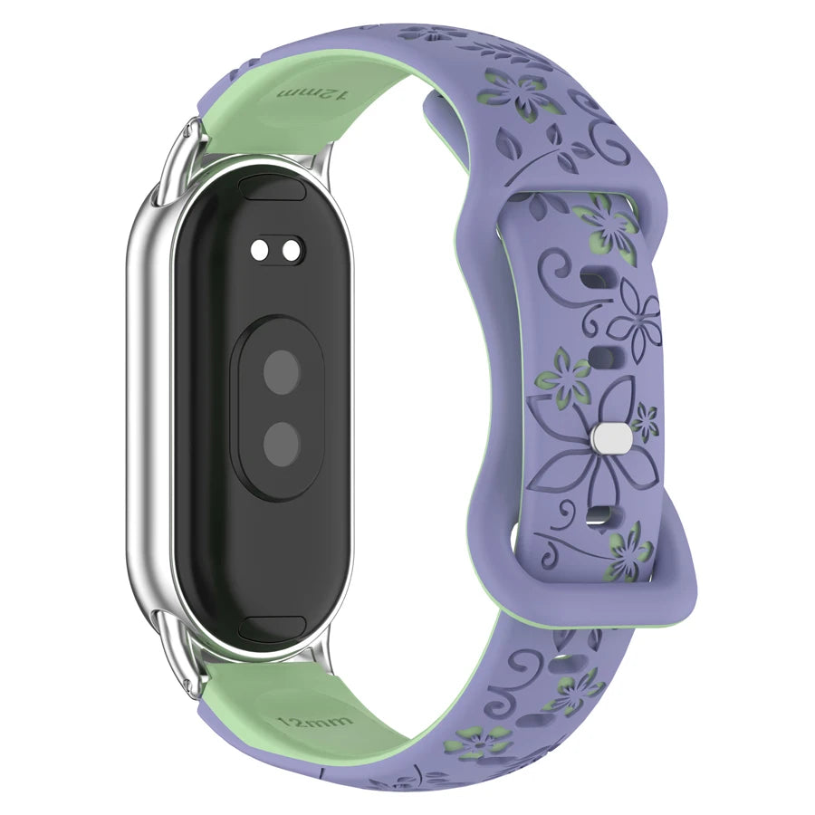 A purple silicone smart watch band with green engraved flowers and a silver casing.