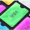 Collection de porte-cartes anti-RFID de couleurs vives, rose, jaune et vert, présentées sur une surface sombre.